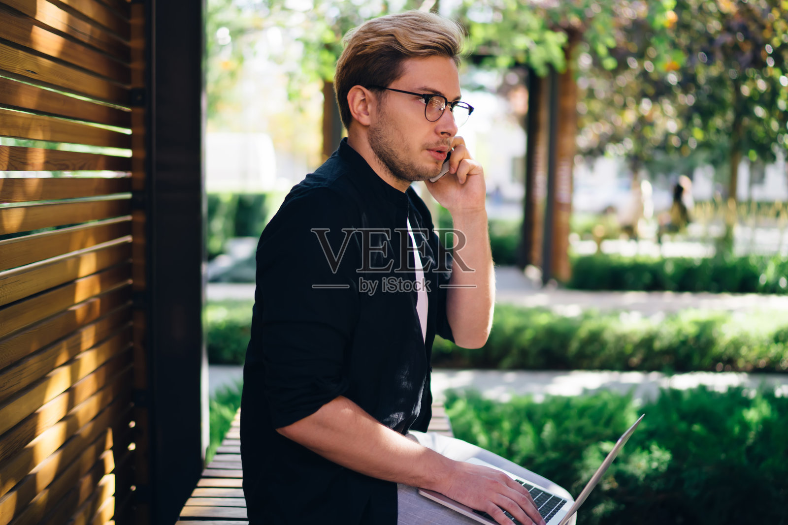 有思想的家伙用笔记本电脑对着智能手机说话照片摄影图片