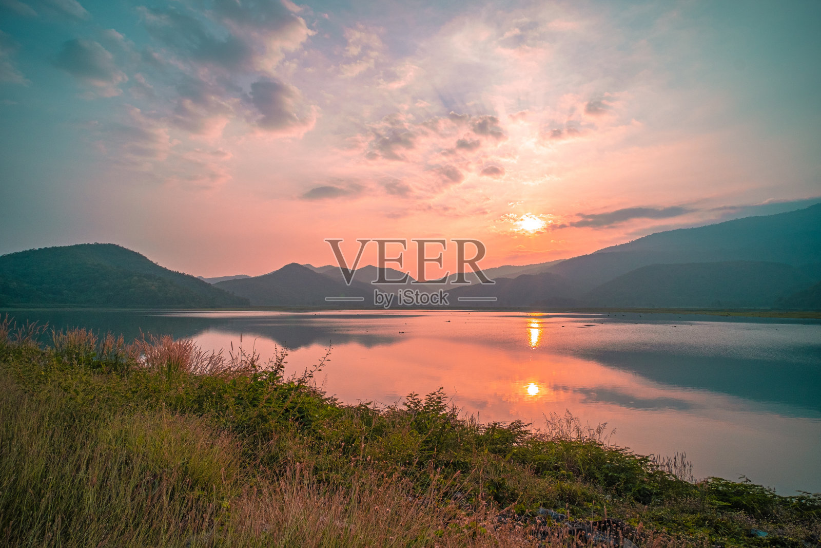 日出时完美反射的山湖全景。美丽的山脉景观与粉红色粉彩天空与山丘的背景，并反映在水中。自然景观湖照片摄影图片