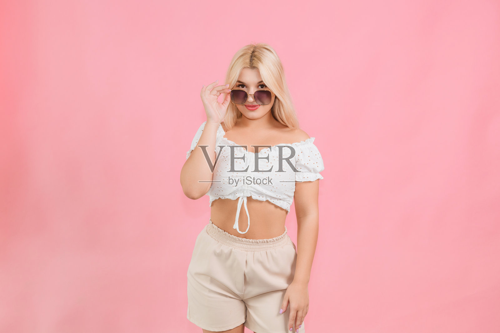 年轻美丽的女孩，穿着轻薄的衣服，戴着粉红色的眼镜照片摄影图片