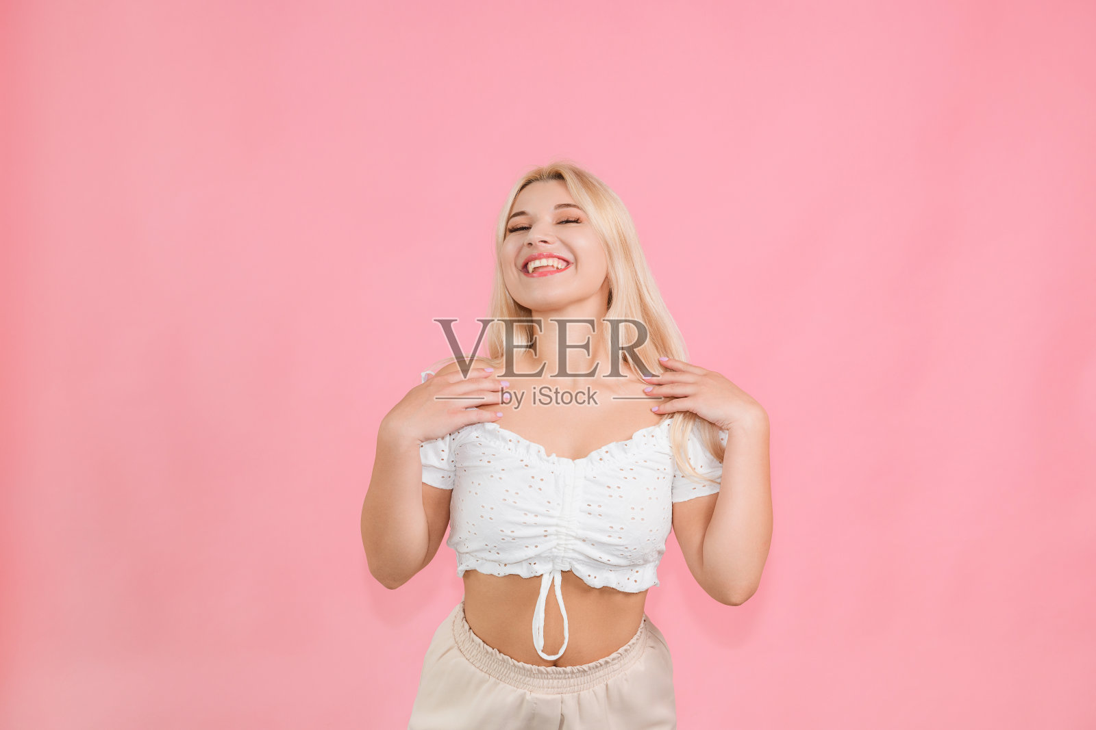 非常漂亮的年轻女孩在粉红色的背景上摆着情绪照片摄影图片