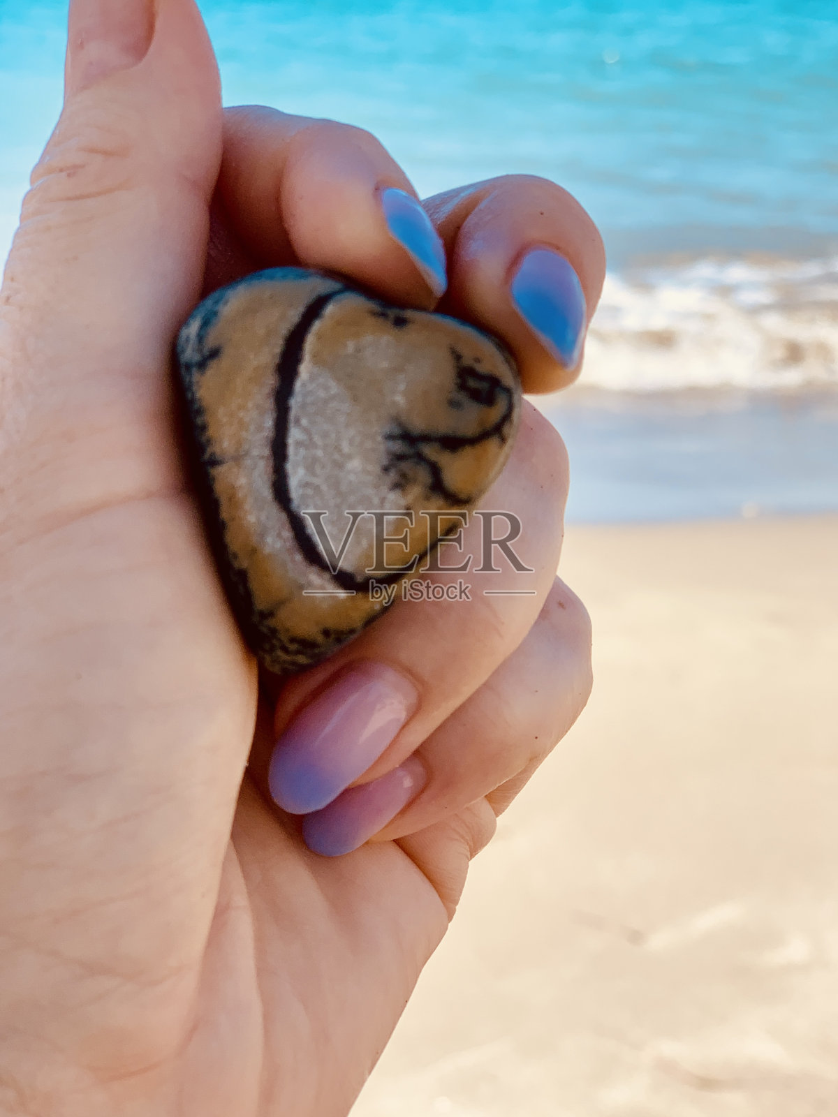 女性手握心形石头照片摄影图片