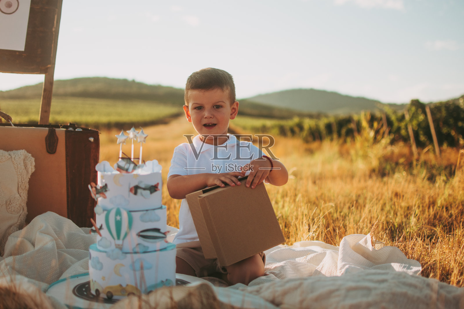 一个可爱的男孩打开一份礼物照片摄影图片