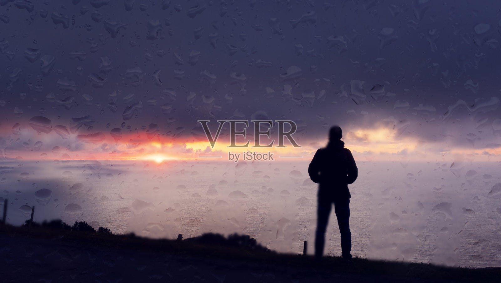 雨滴落在窗户上和雨中的人在日落前的大海，尤斯卡迪照片摄影图片