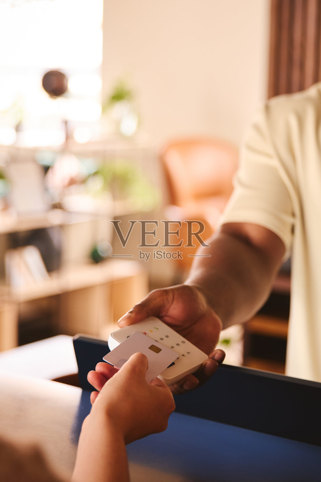 愉快的销售助理在零售商店与客户使用非接触式支付信用卡NFC支付照片摄影图片