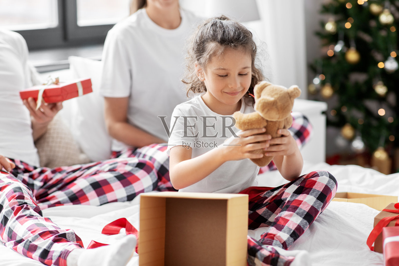 幸福的家庭在家里的床上放着圣诞礼物照片摄影图片