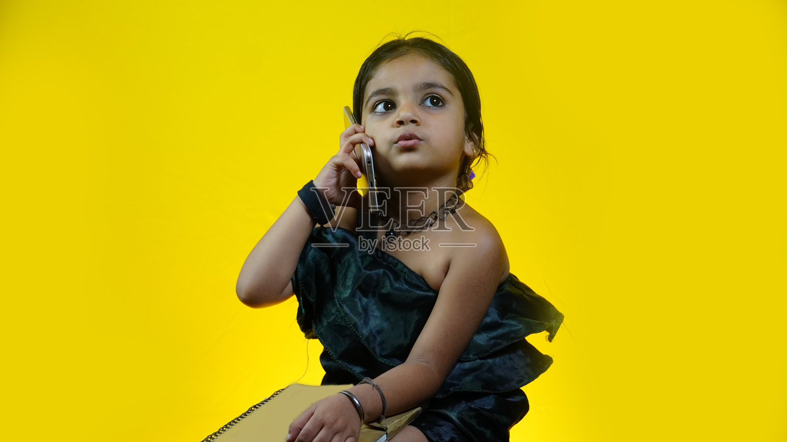 生活方式概念-肖像美丽和快乐的小女孩谈在手机上与爸爸。照片摄影图片