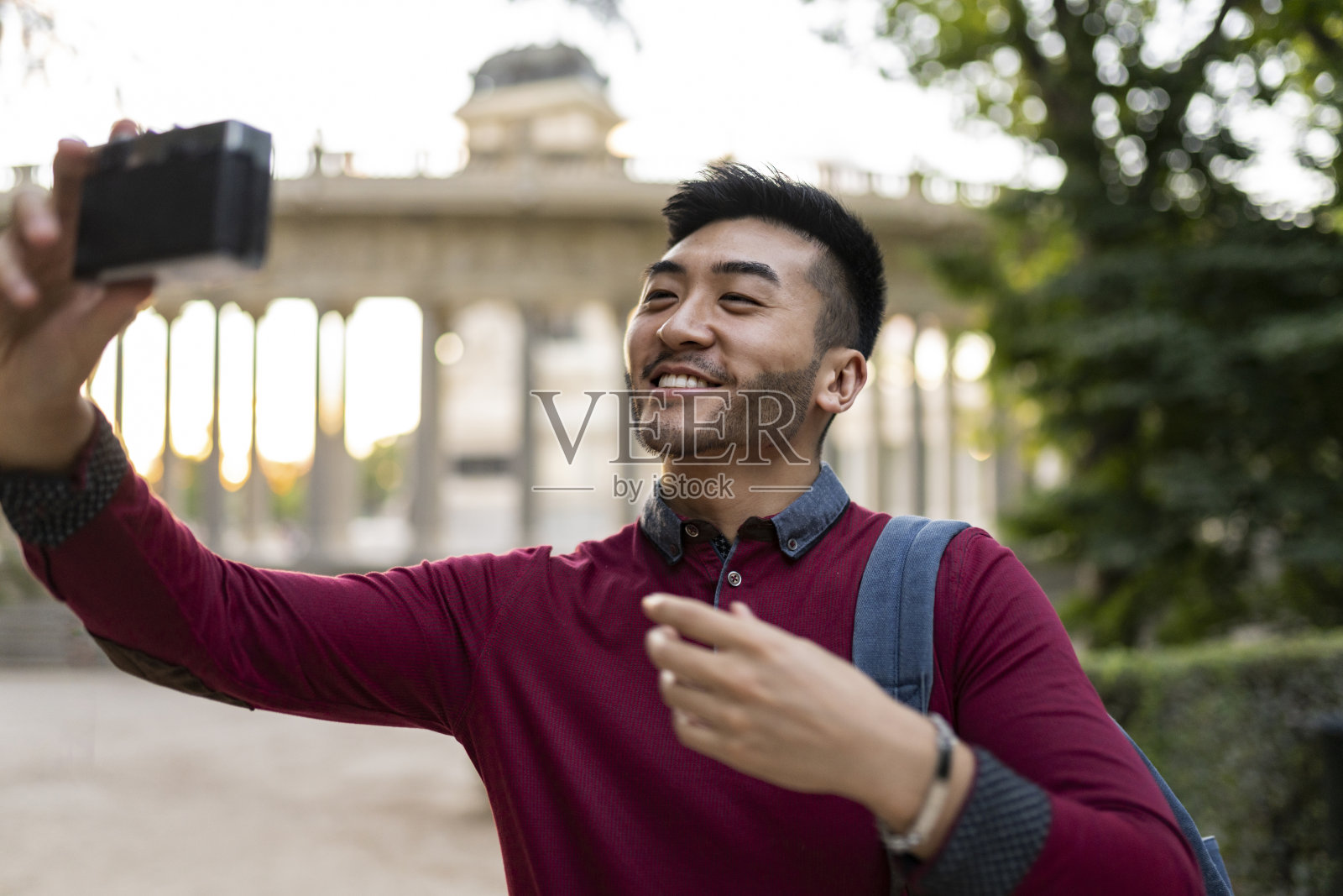 年轻的日本男子带着相机在城市旅行照片摄影图片