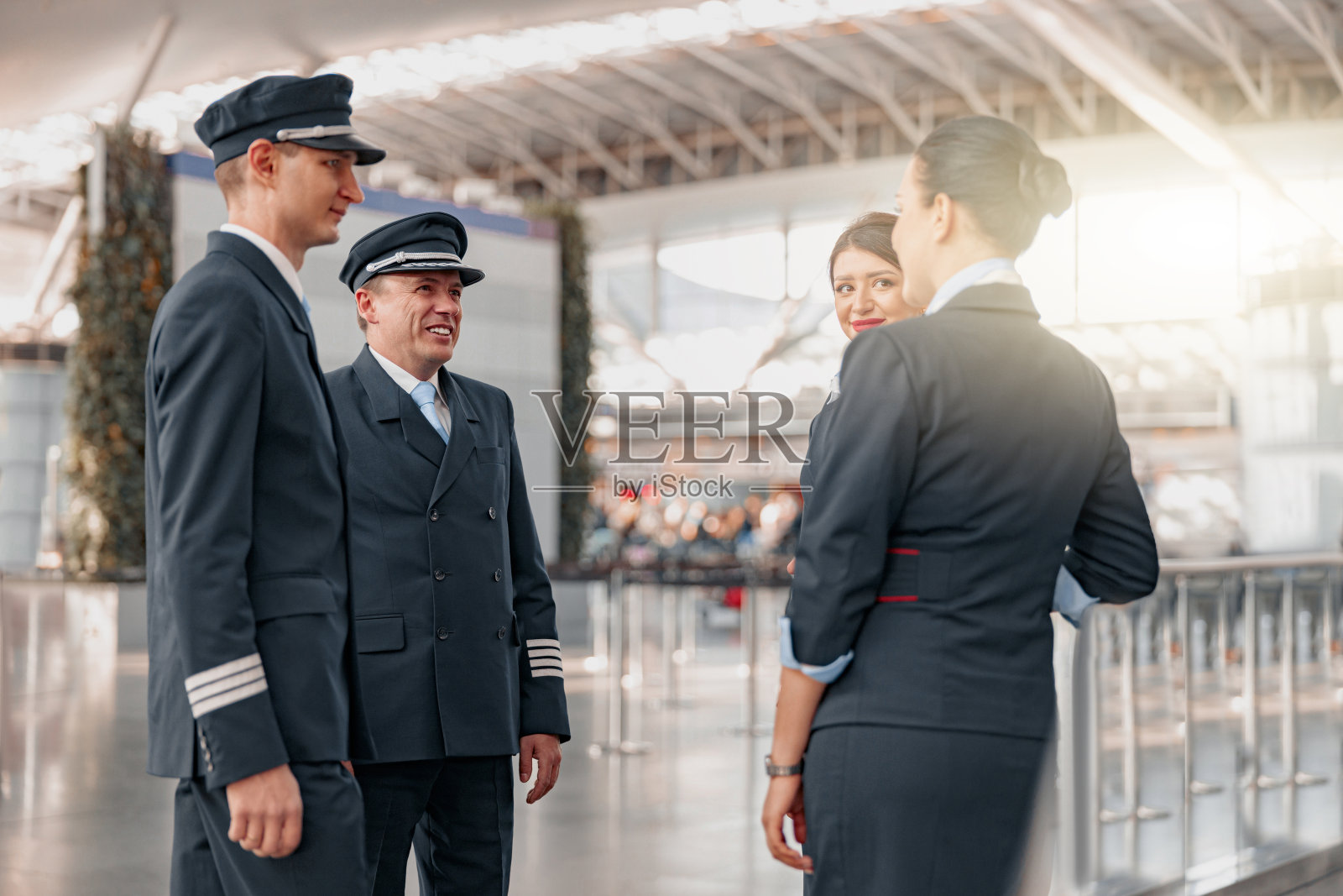 愉快的飞机团队在机场候机楼站着聊天照片摄影图片