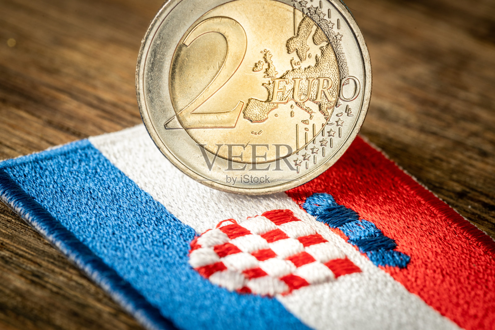 克罗地亚国旗放在欧元硬币旁边。克罗地亚加入欧元区。欧盟的概念、国旗、政治经济概念照片摄影图片