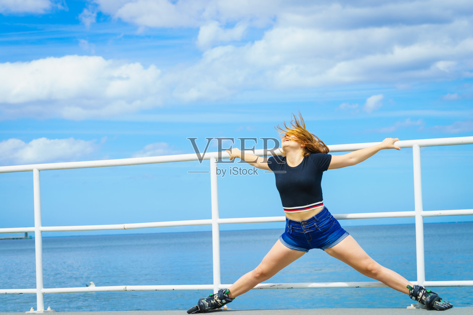 女孩穿着溜冰鞋在海边照片摄影图片