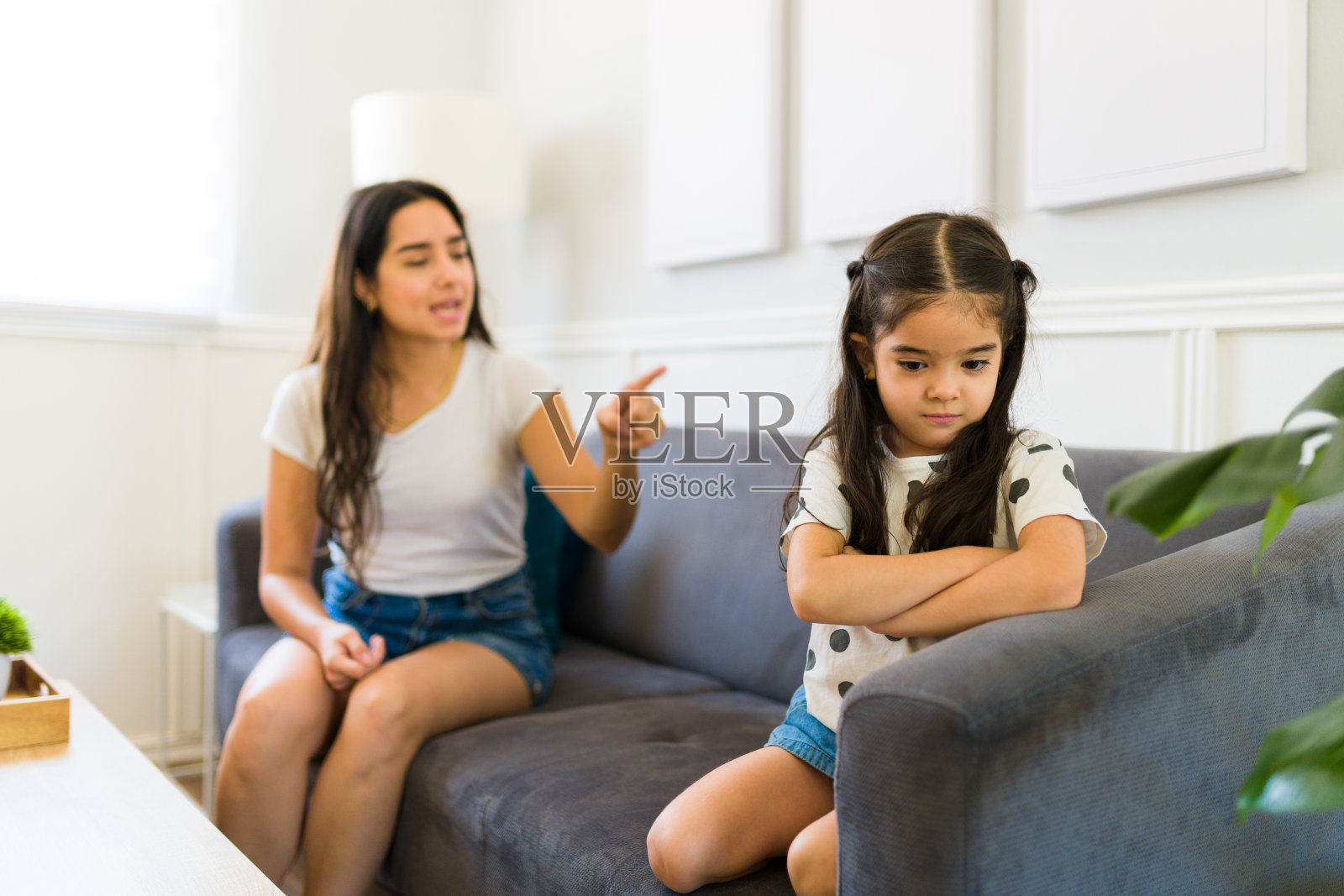 心烦意乱的小女孩因为母亲的责骂而显得很伤心照片摄影图片