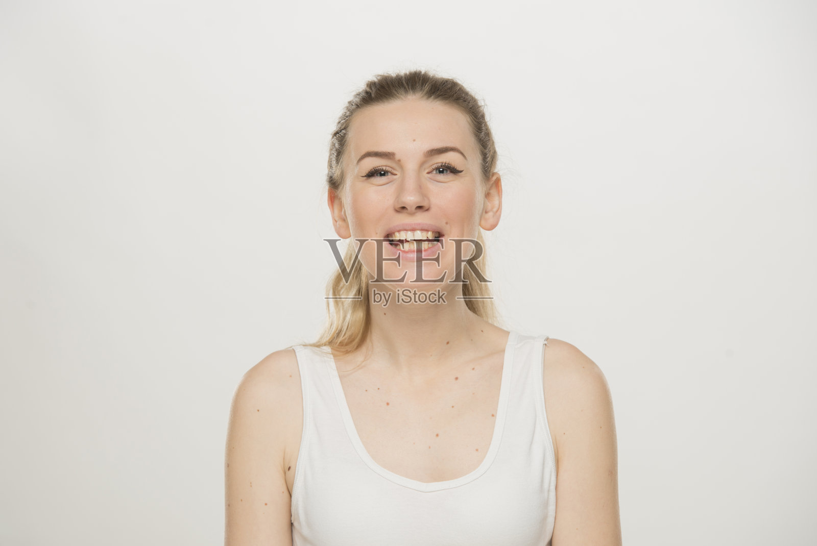 一个美丽的年轻女人的肖像，穿着白t恤，微微微笑，孤立在白色照片摄影图片