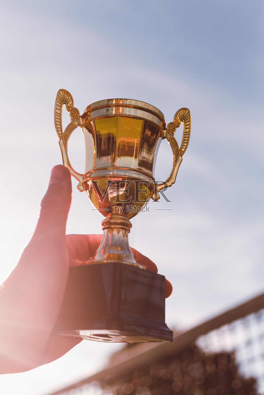 金杯在手的体育比赛冠军与发挥网的背景照片摄影图片