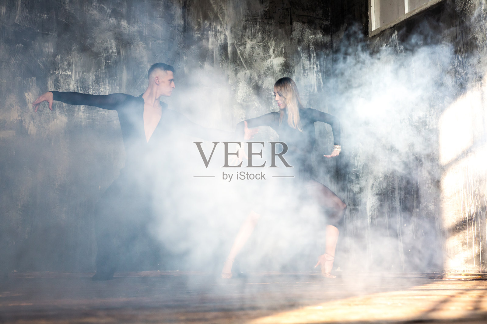 一对专业交谊舞舞者正在阁楼工作室跳舞。美丽的艺术表演。运动生活的概念。激情与情感的舞蹈。照片摄影图片