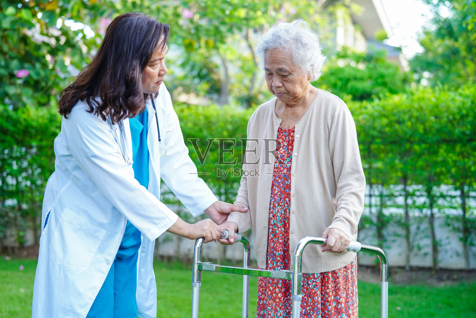 医生在护理医院用助行器帮助亚洲老年妇女残疾患者行走，医疗理念。照片摄影图片