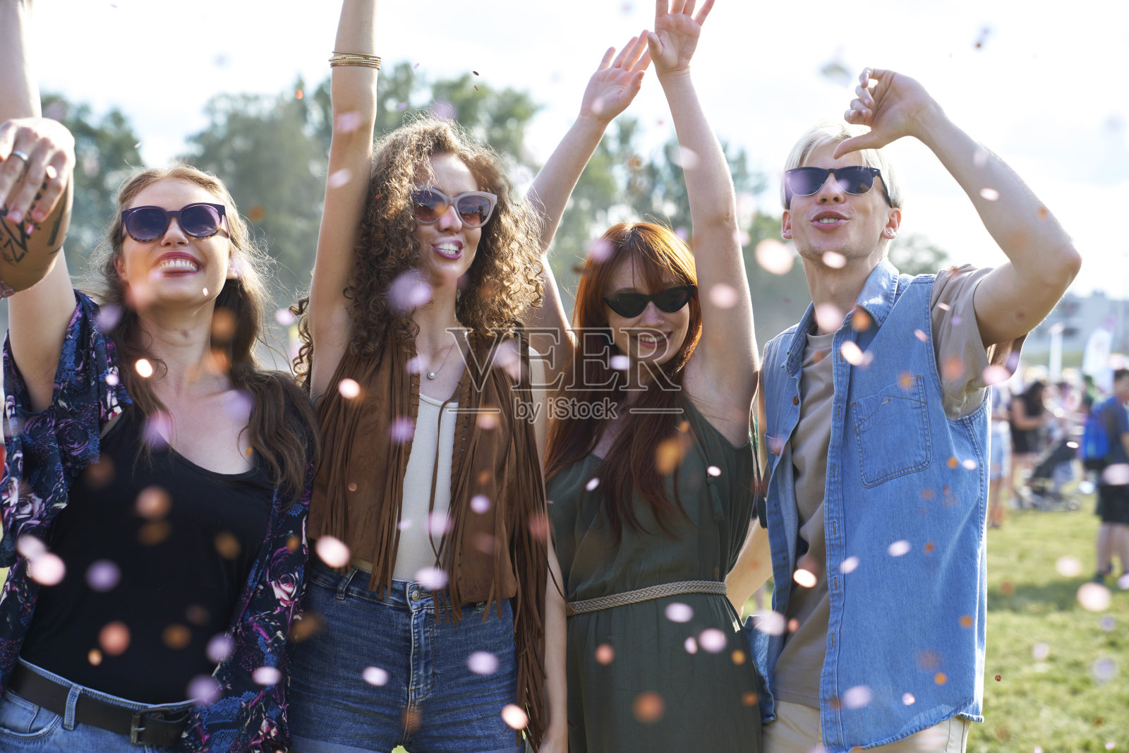 一群年轻的白人朋友在音乐节上跳舞，在五彩纸屑中玩得很开心照片摄影图片