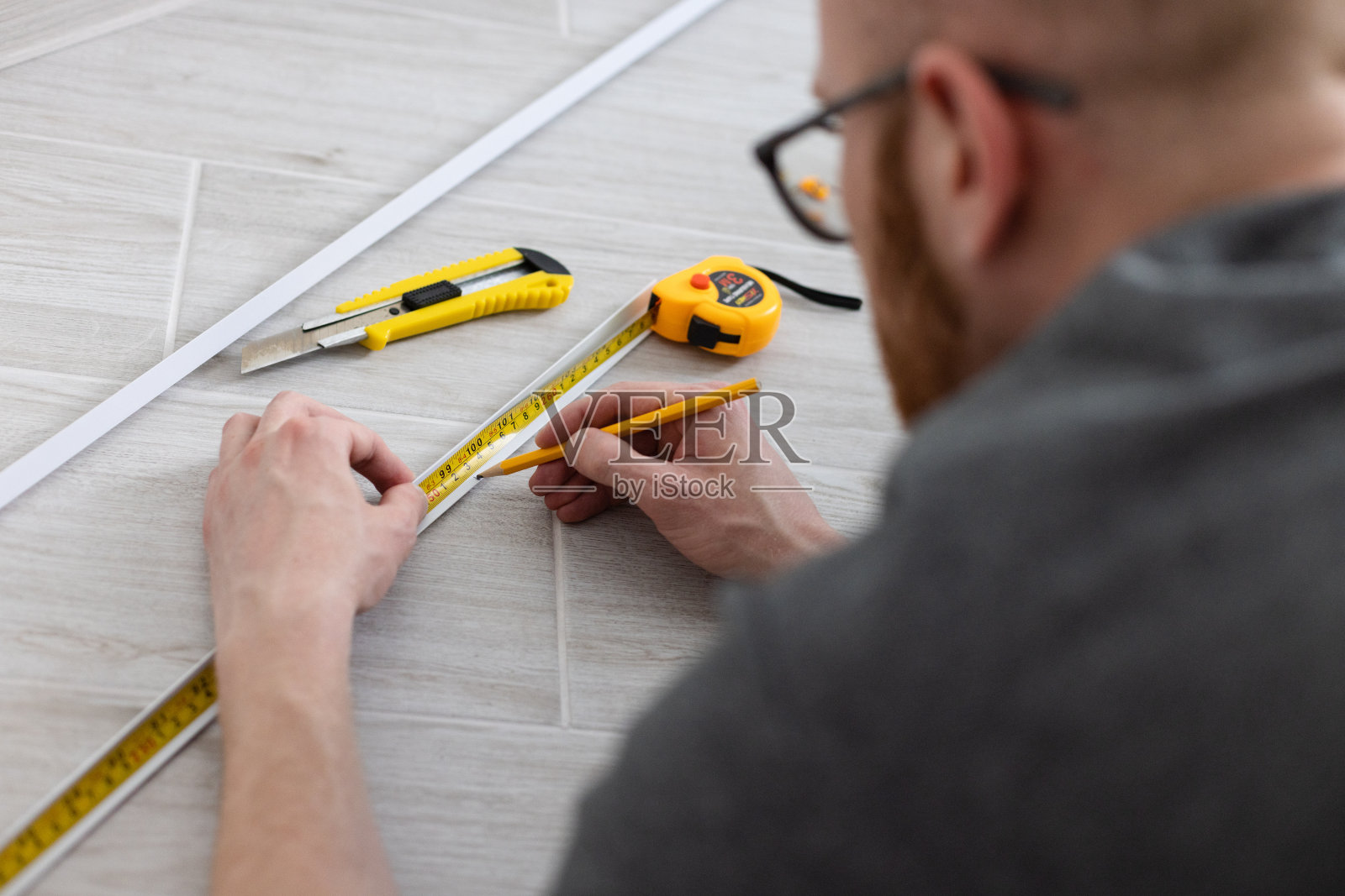 测量装饰塑料角。有测量工具的人。照片摄影图片