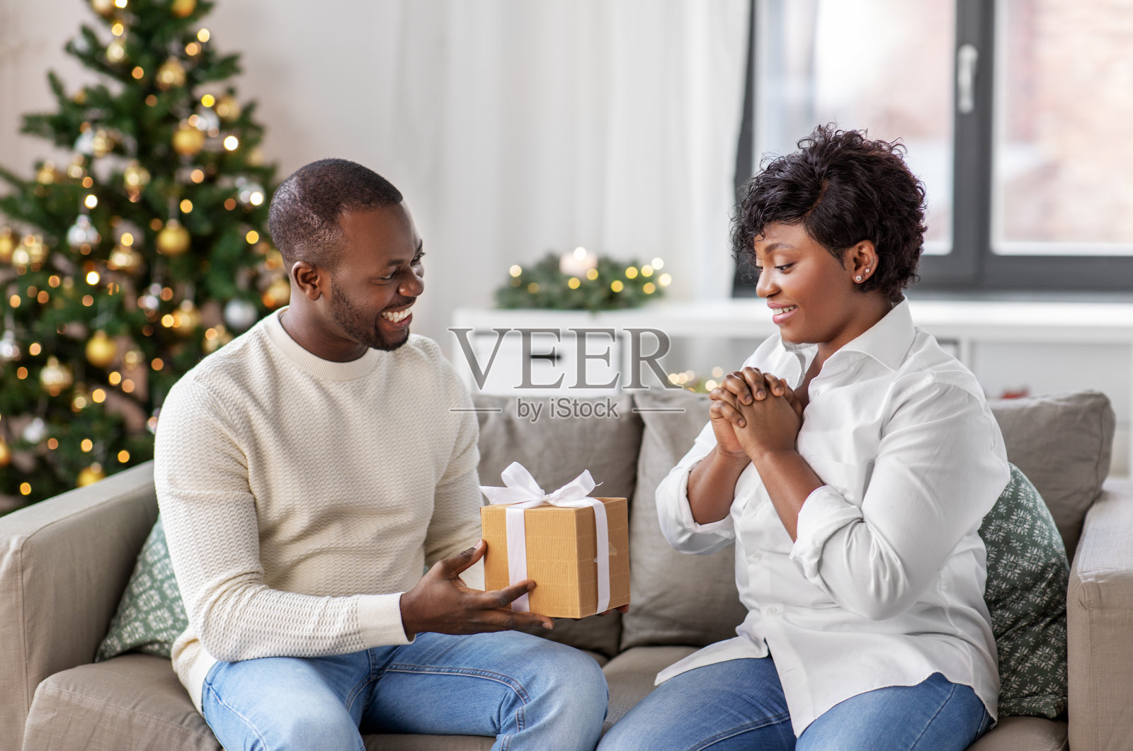 快乐的非洲夫妇与圣诞礼物在家里照片摄影图片
