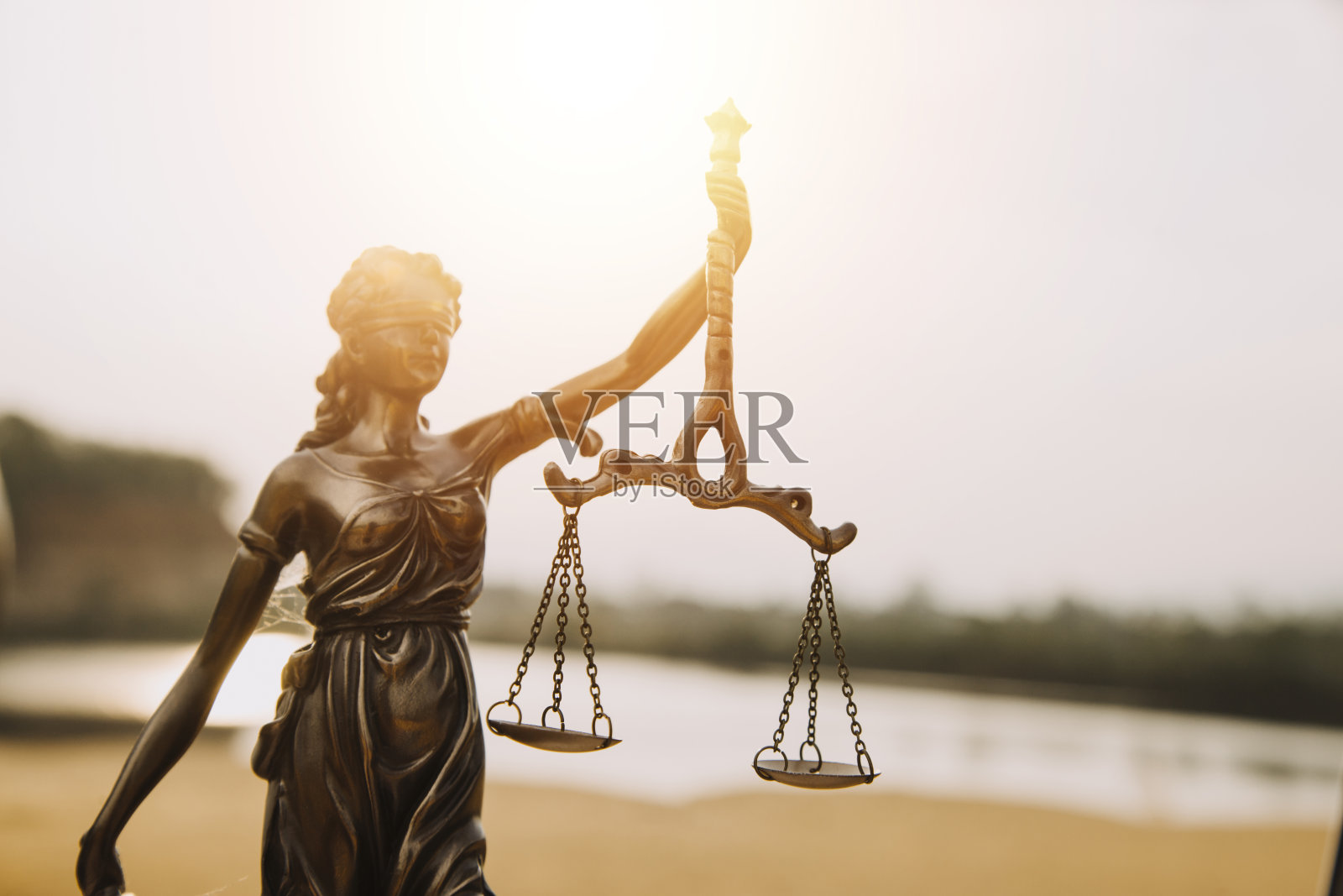 公正与法律观念。男法官在法庭上拿着小木槌，用电脑和对接键盘工作，戴着眼镜，在晨光中坐在桌子上照片摄影图片