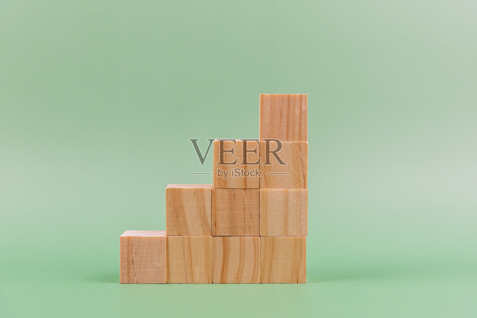 木块堆叠在绿色背景上照片摄影图片