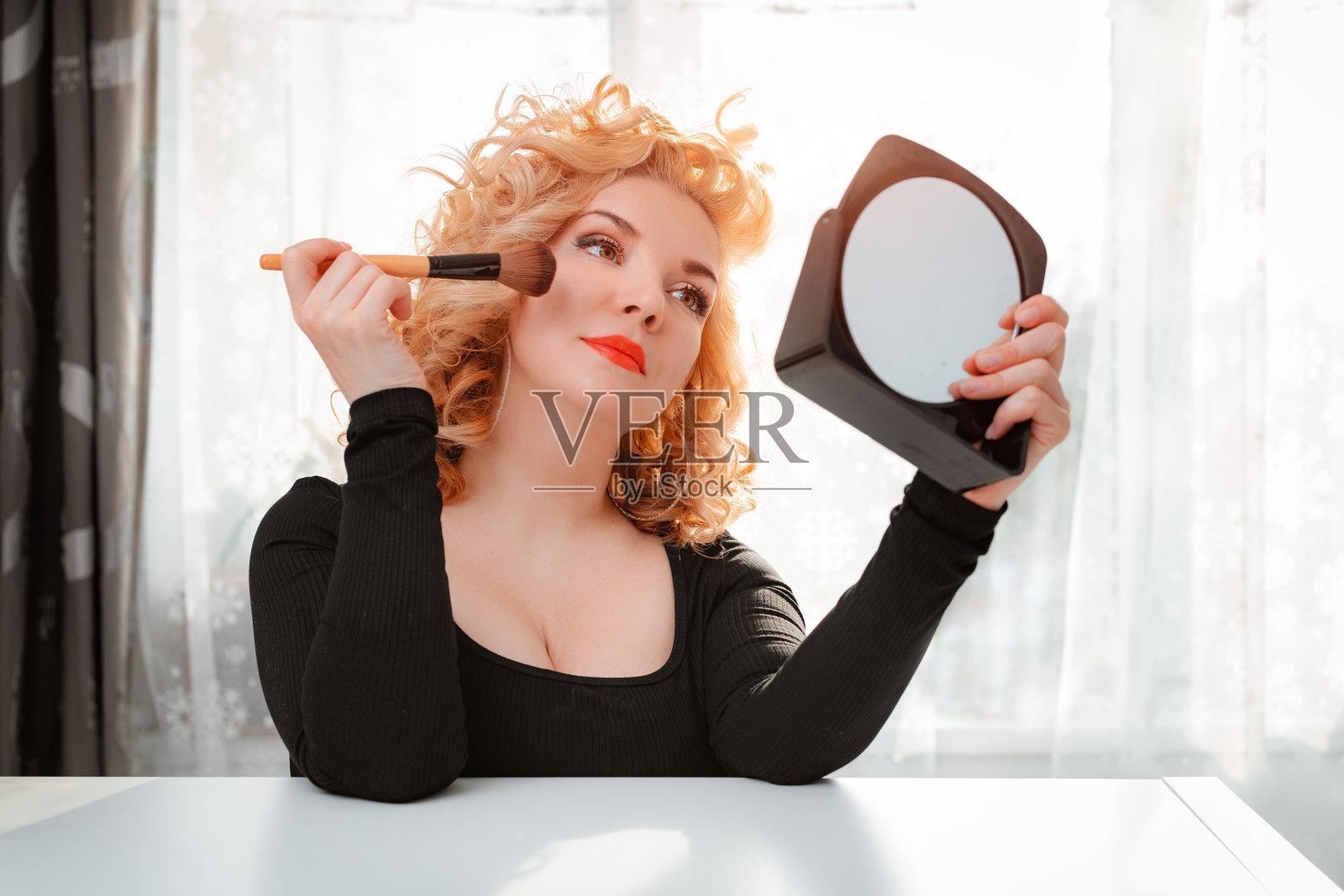 金发与复古的头发明亮的红色唇膏唇和化妆前镜。旧好莱坞看。肖像美丽的35-40岁女性迷人的庸俗形象照片摄影图片