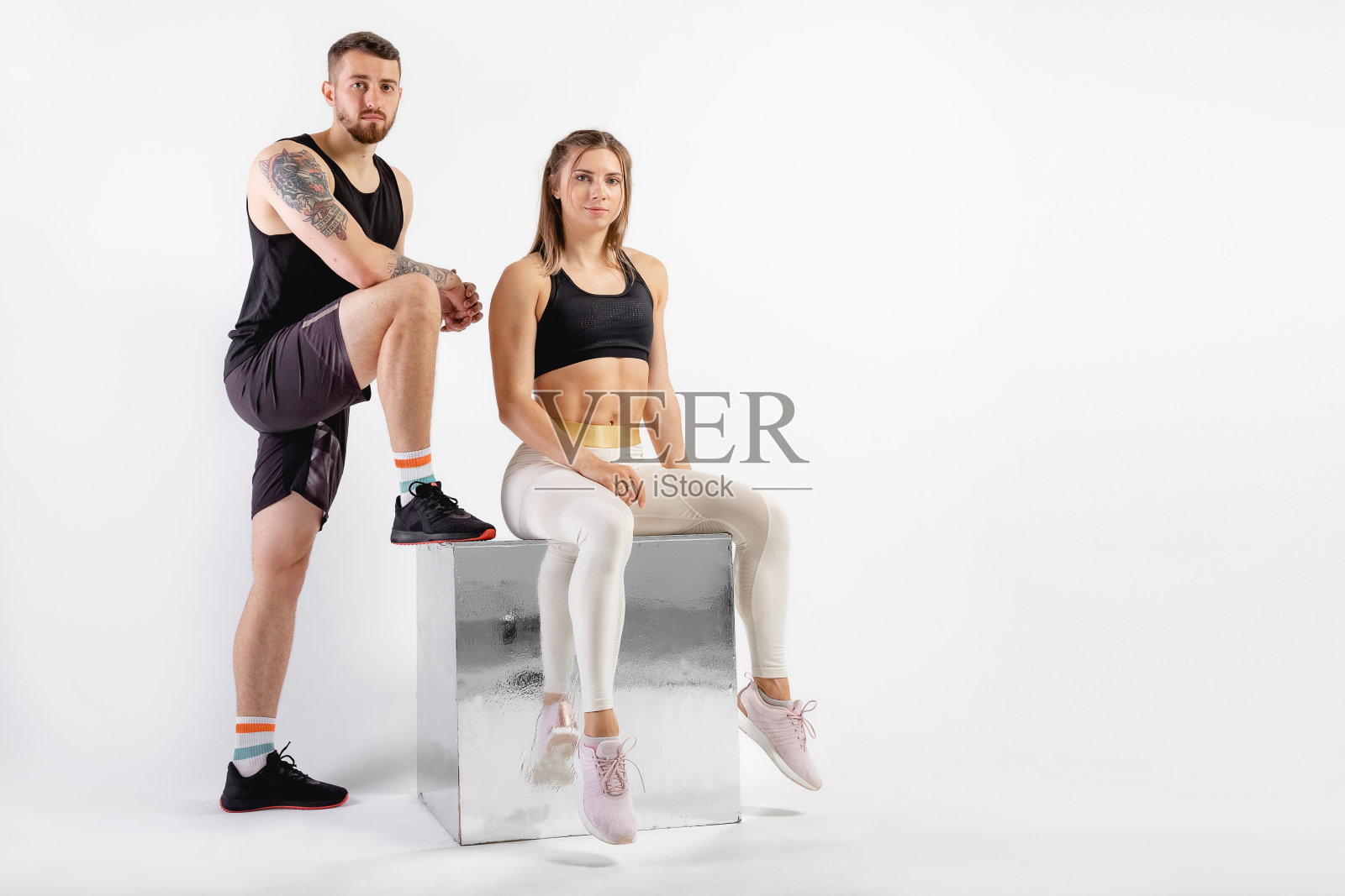 摄影棚中男女合影。健身理念，锻炼肌肉。专业运动员，适合摄影。两个人在做运动照片摄影图片