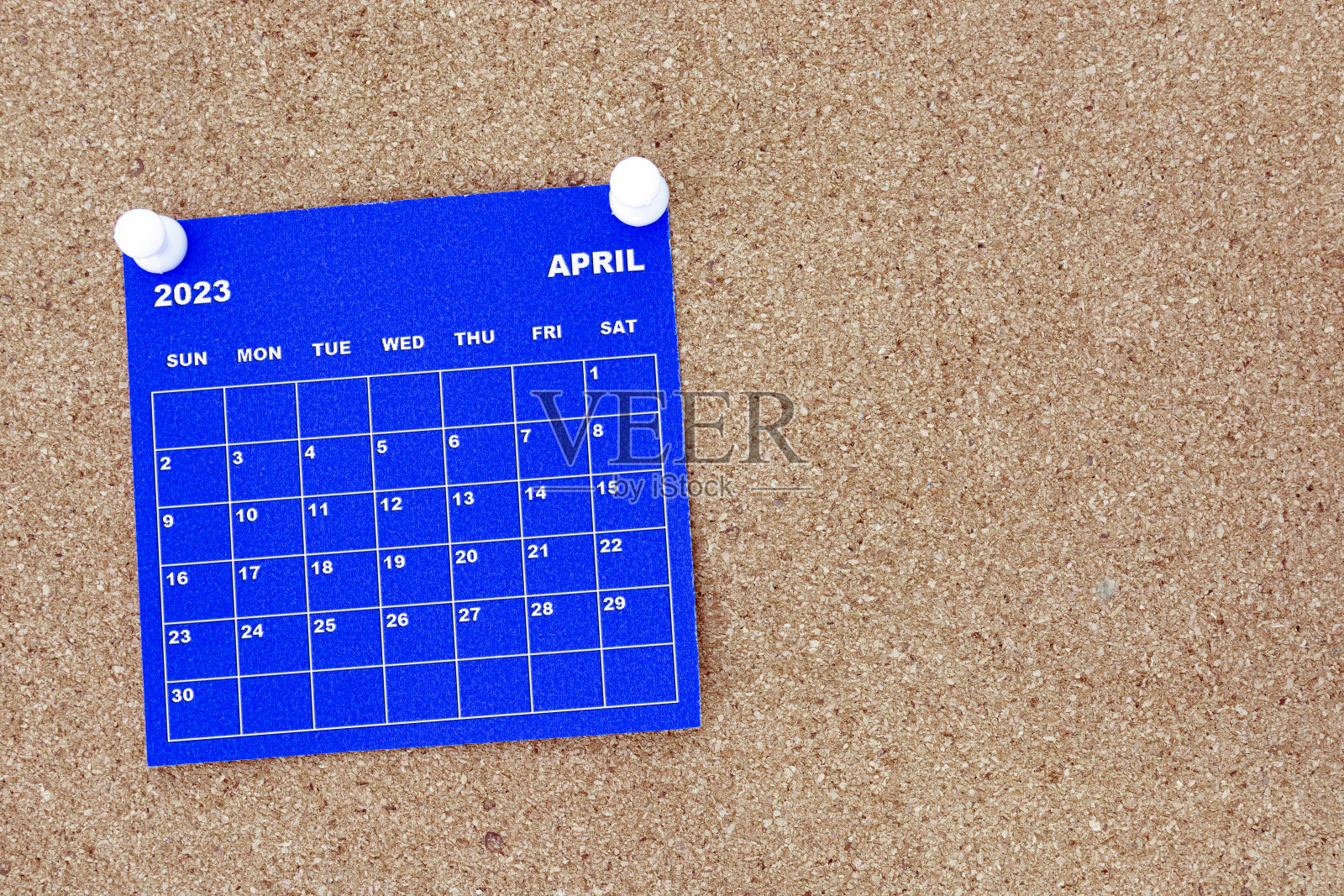 2023年4月蓝色日历与别针在软木公告牌广告牌。照片摄影图片