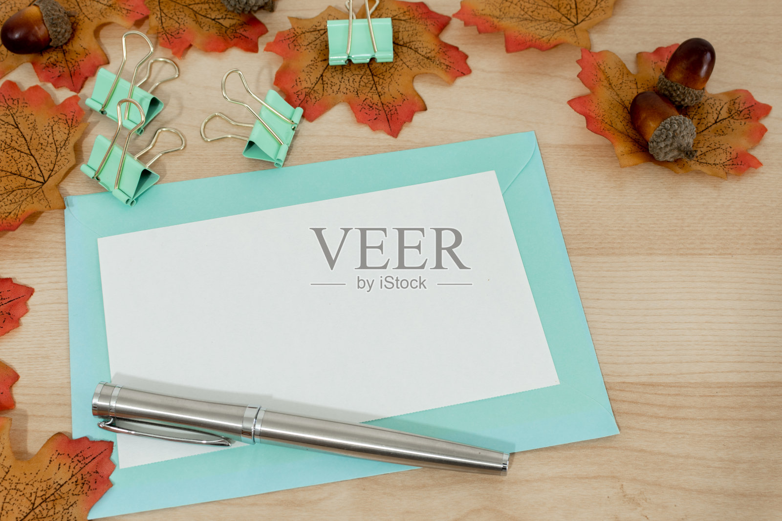 感恩节祝福：木质背景上的黄色落叶、坚果和钢笔照片摄影图片