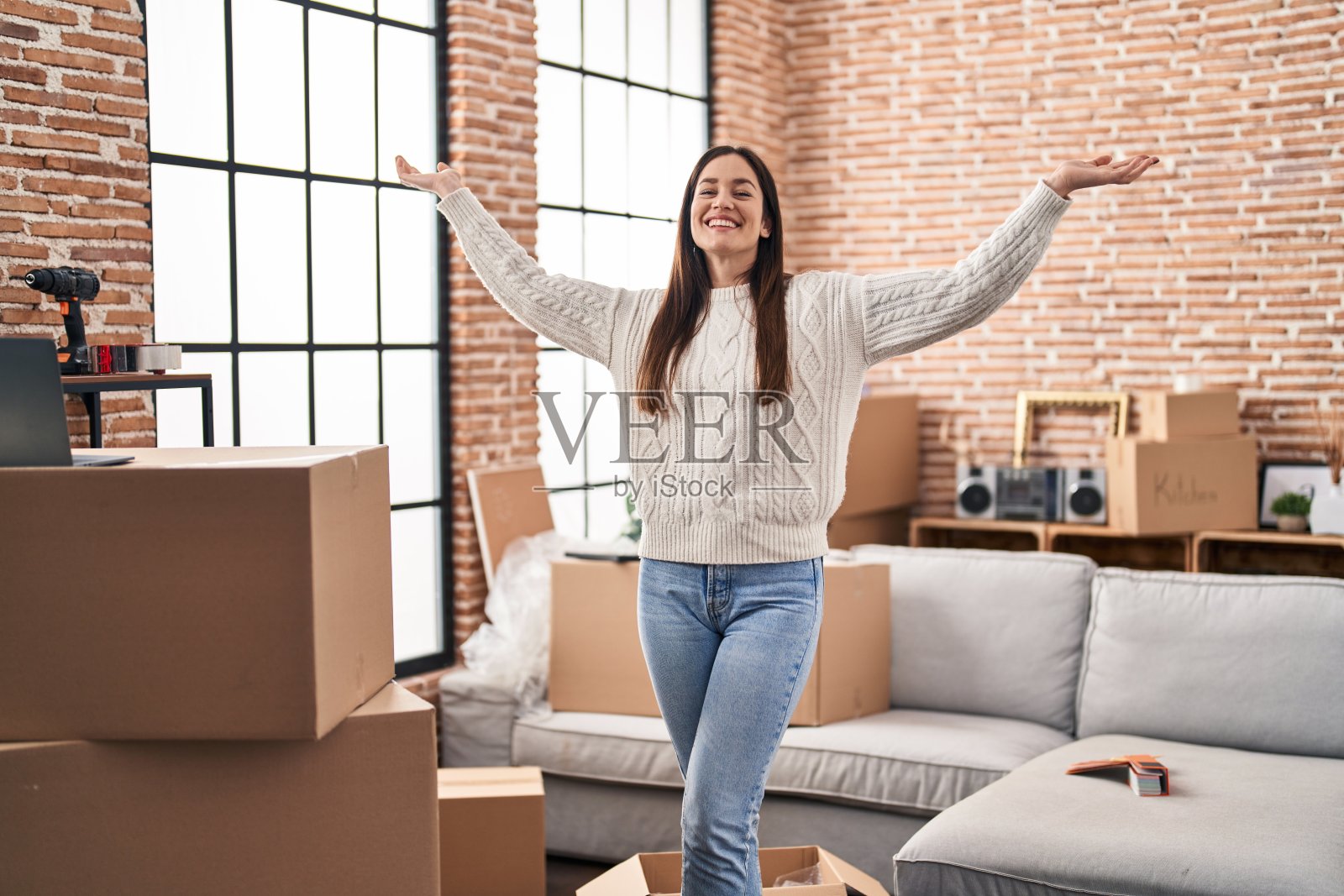 年轻女子张开双臂站在新家照片摄影图片