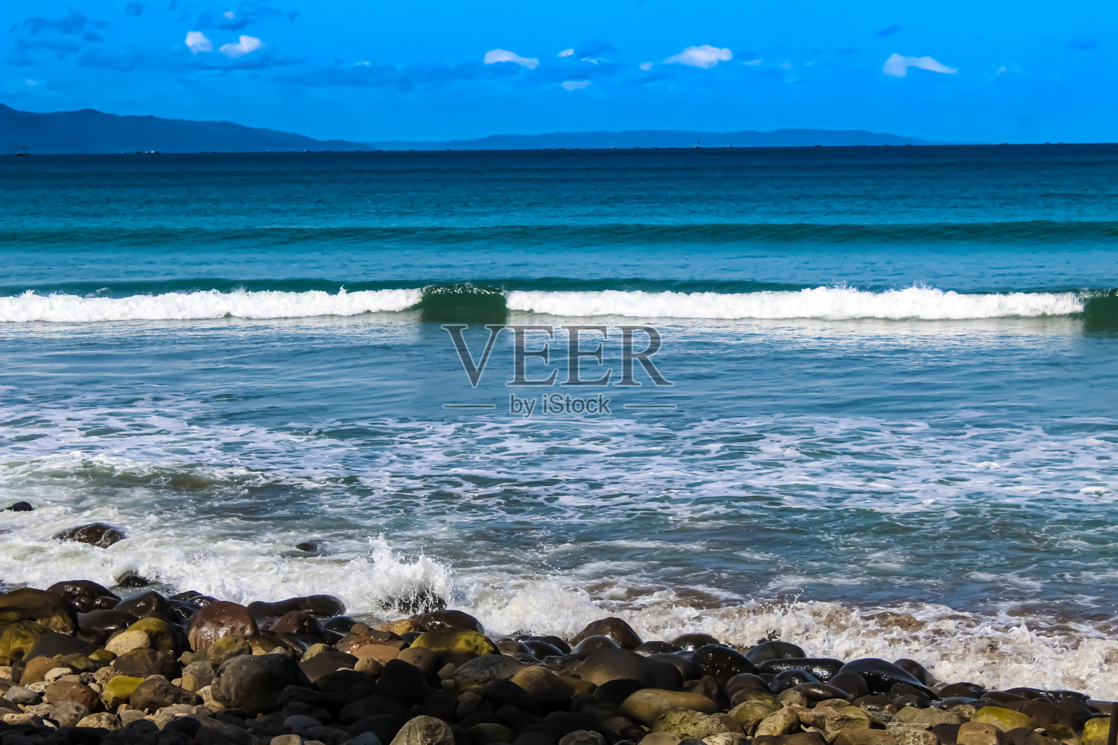 海浪滚滚地涌向海滩照片摄影图片