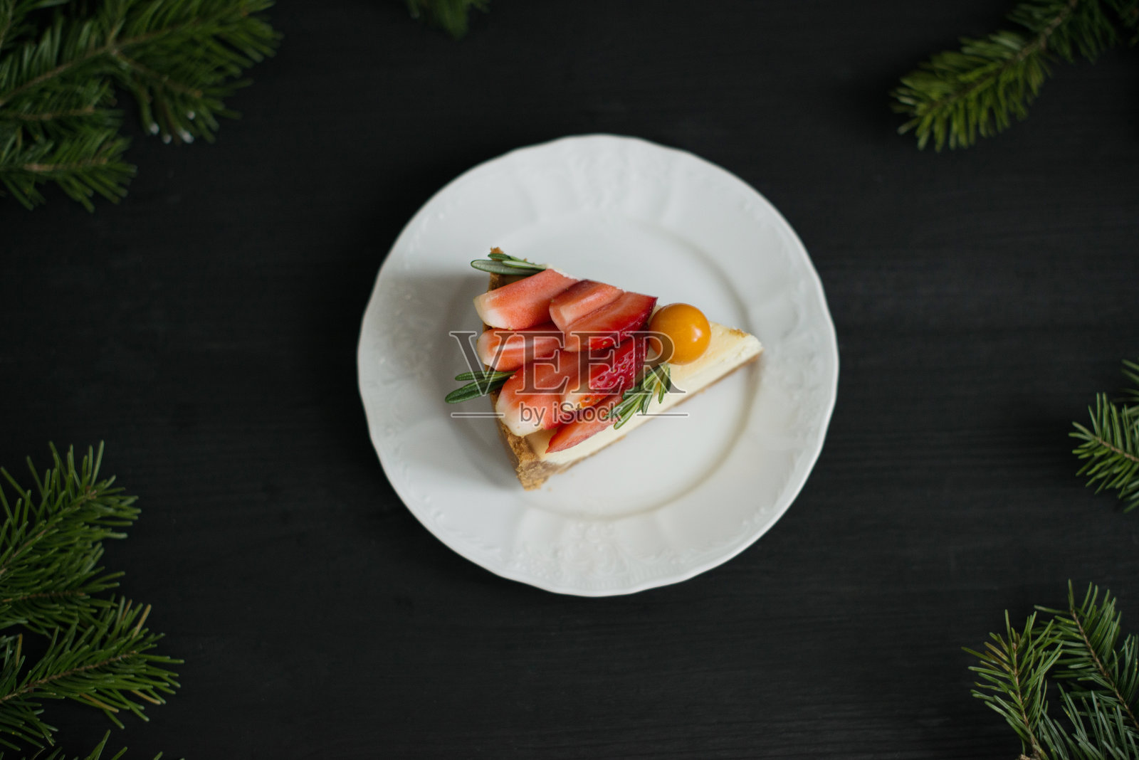 美味的芝士蛋糕，黑色背景上装饰着水果照片摄影图片