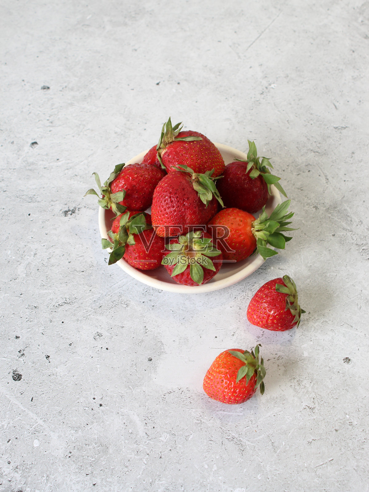 明亮的特写照片一个美味的草莓在一个白色的碗。健康的食物照片摄影图片