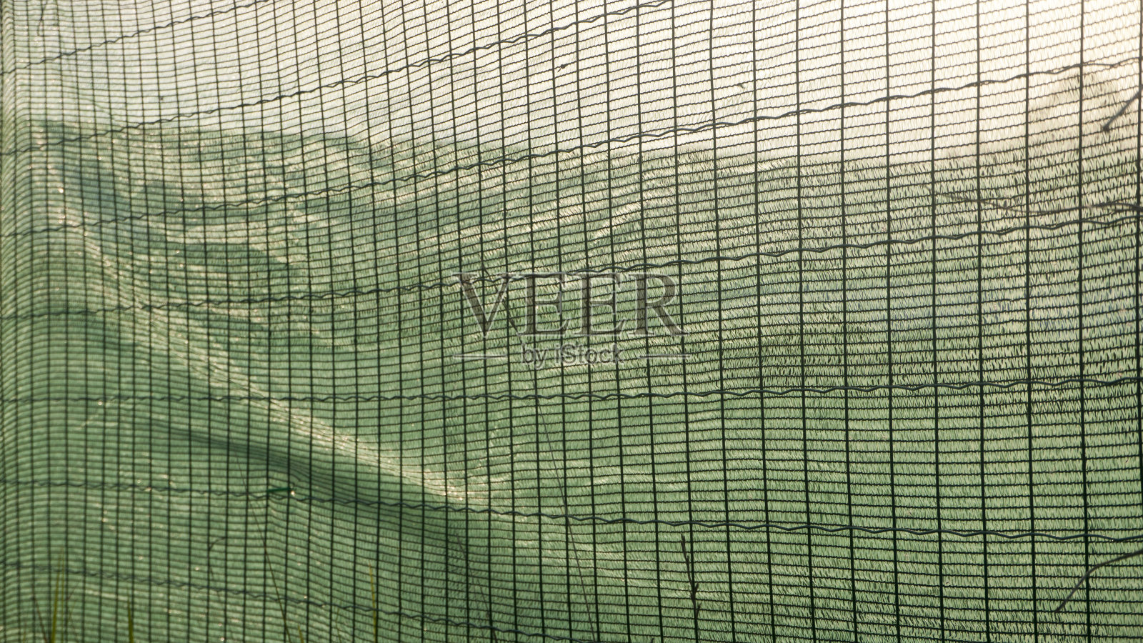 金属丝篱笆上的绿色塑料箔照片摄影图片