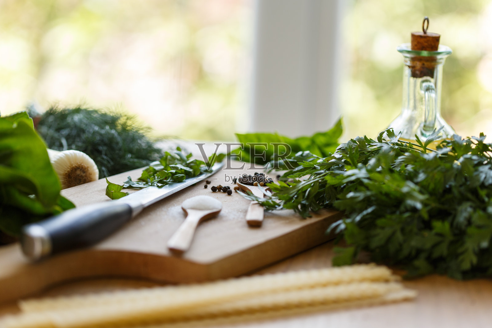 混合绿色香草，意大利面，胡椒和油摆放在厨房柜台上照片摄影图片