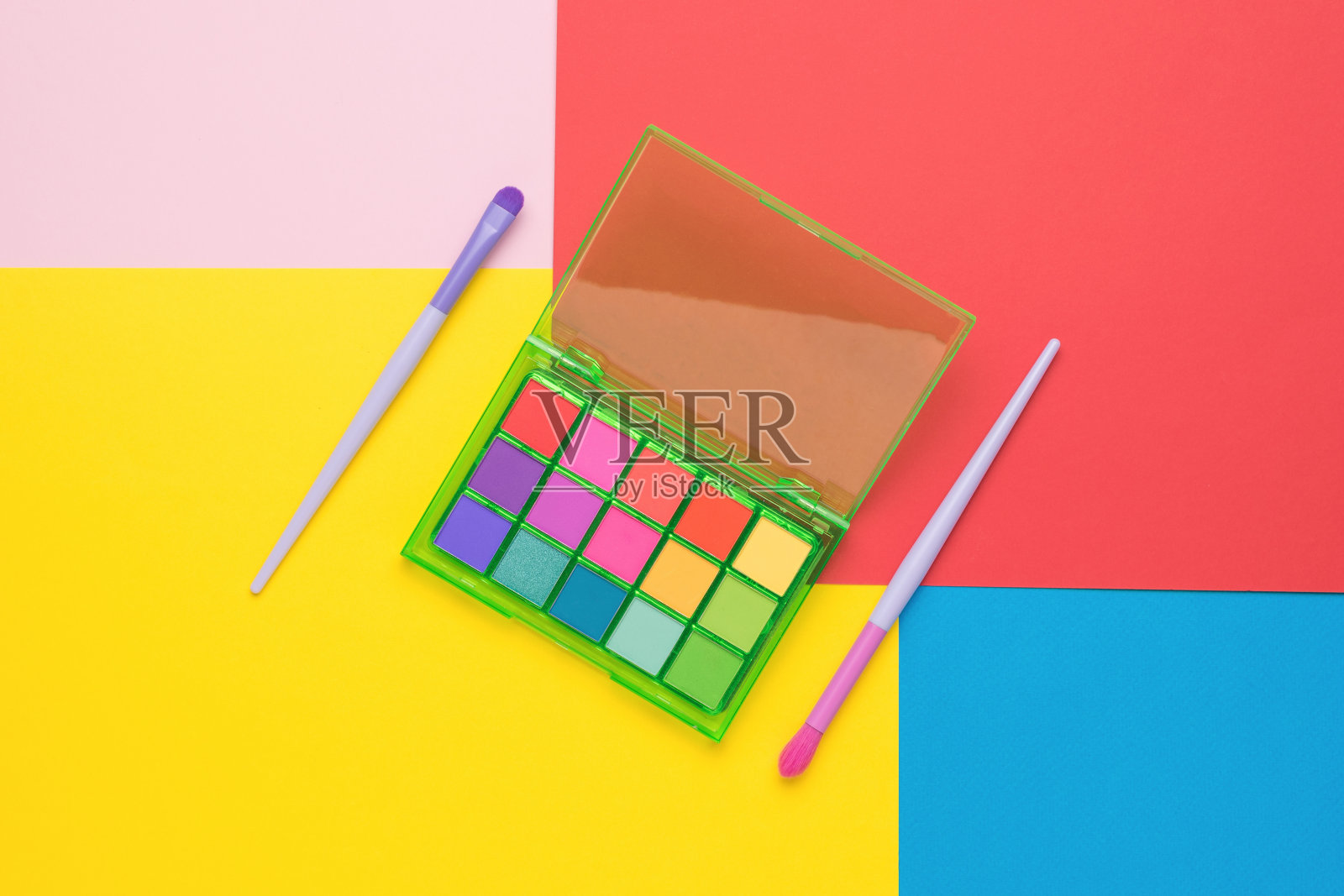 两支刷子和一套五彩背景的眼影。平的。照片摄影图片