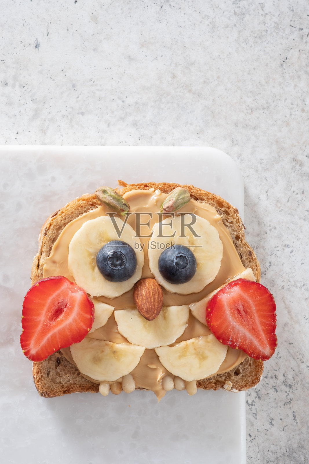 孩子们的早餐吐司涂有花生酱，香蕉，草莓照片摄影图片