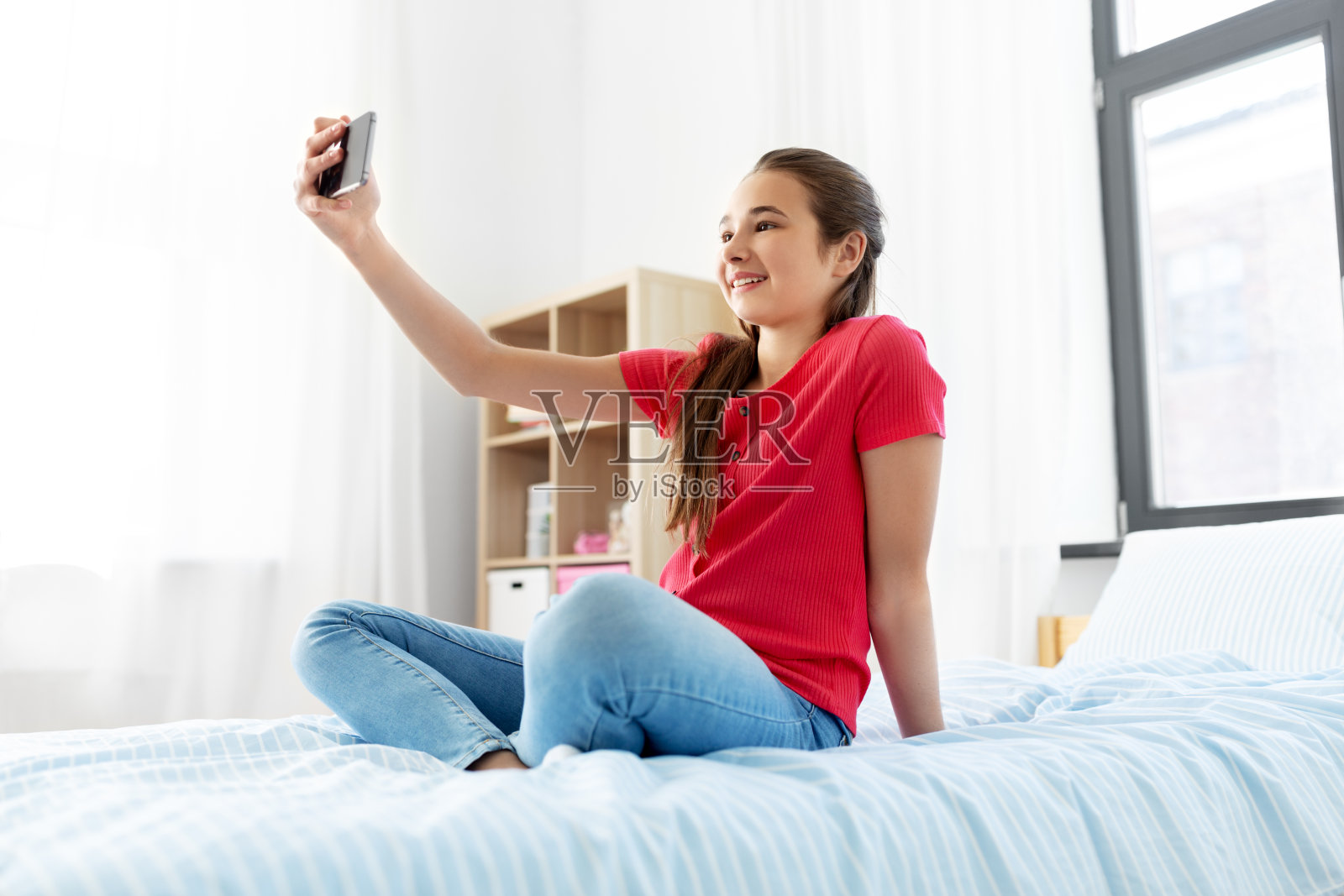 在家用智能手机自拍的快乐女孩照片摄影图片