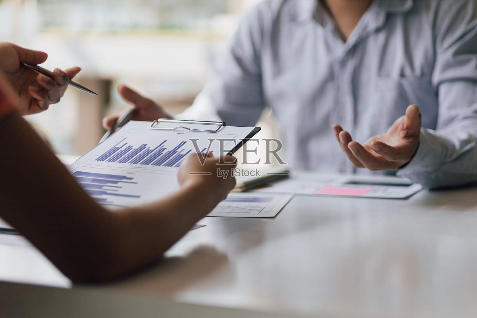 在讨论财务分析和市场文件时开会。商务人士谈论商业策略和图表显示投资增长的成功团队合作的结果。照片摄影图片