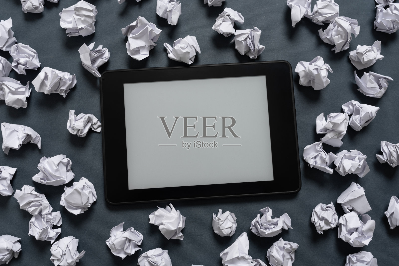 平板电脑屏幕上的重要信息，它被纸包裹着。皱巴巴的笔记周围的Pad与关键信息。布满关键数据的皱巴巴的备忘录。照片摄影图片