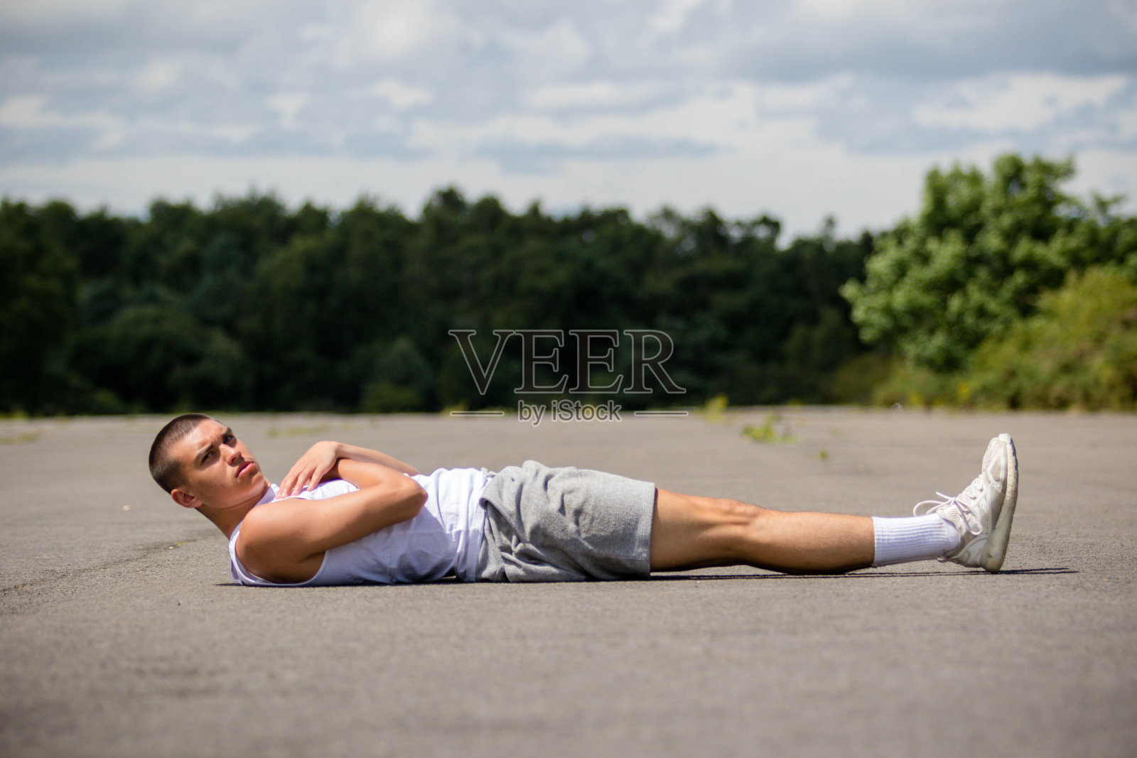 一个19岁的少年在公园里做抬腿动作照片摄影图片