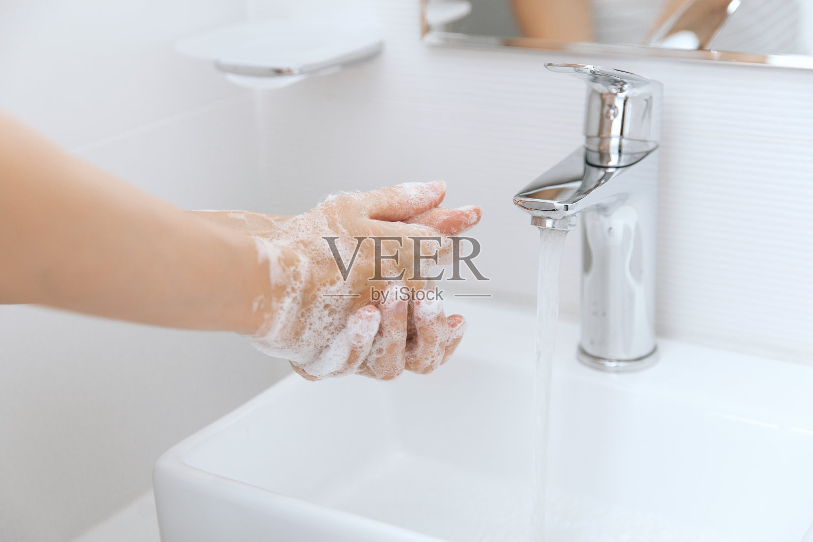 在水龙头下洗手。卫生概念手细节。勤洗手，用肥皂搓手，防止冠状病毒在公共厕所或公共厕所传播照片摄影图片