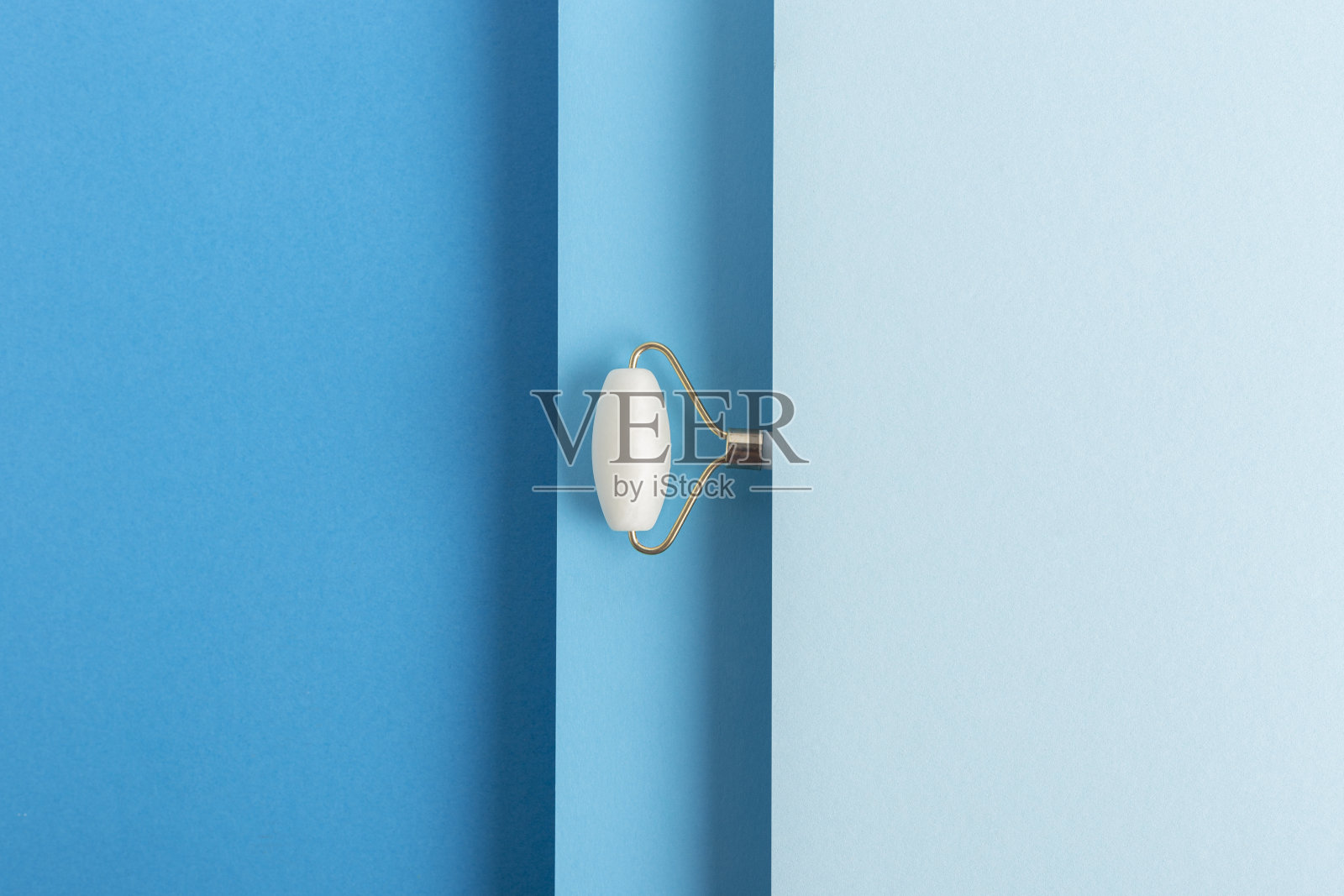 面部按摩器放在折叠的蓝色纸板背景上。俯视图，平铺照片摄影图片