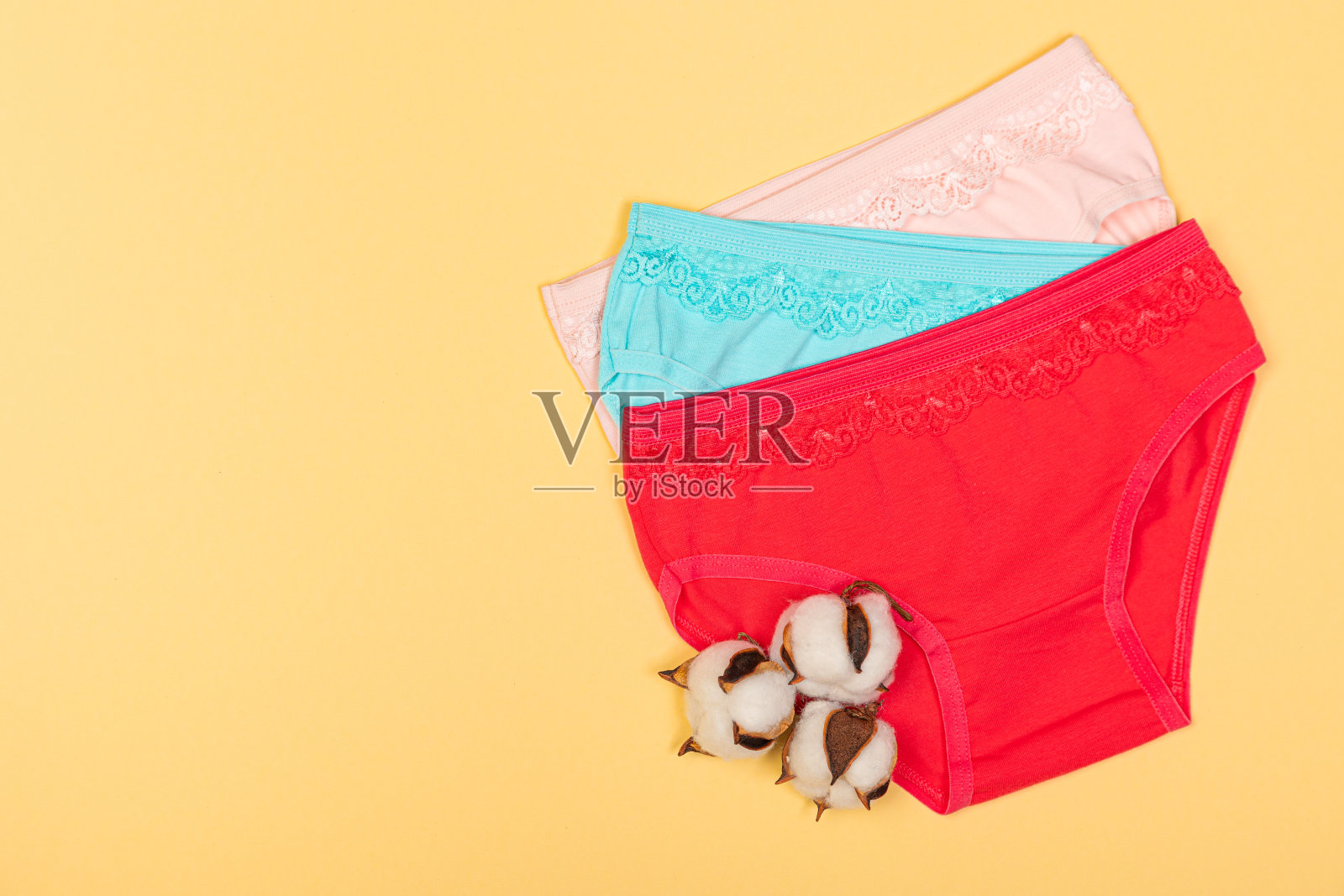 童装:童装的形式。柔软布料的儿童衣服。女孩的内裤。一套儿童内裤。从以上观点。内衣集。黄色背景的内衣照片摄影图片