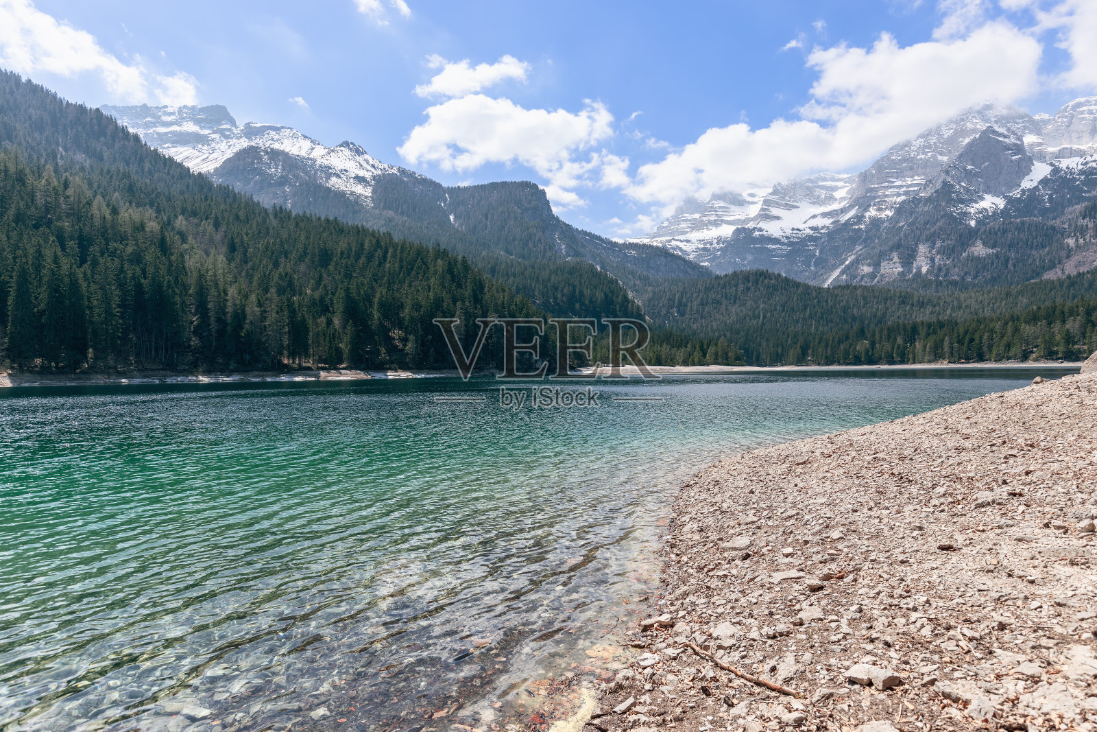 意大利特伦蒂诺的奥纳尼亚城，高山托维尔湖的岸边缓缓倾斜，湖水呈翠绿色，湖面上泛起涟漪照片摄影图片