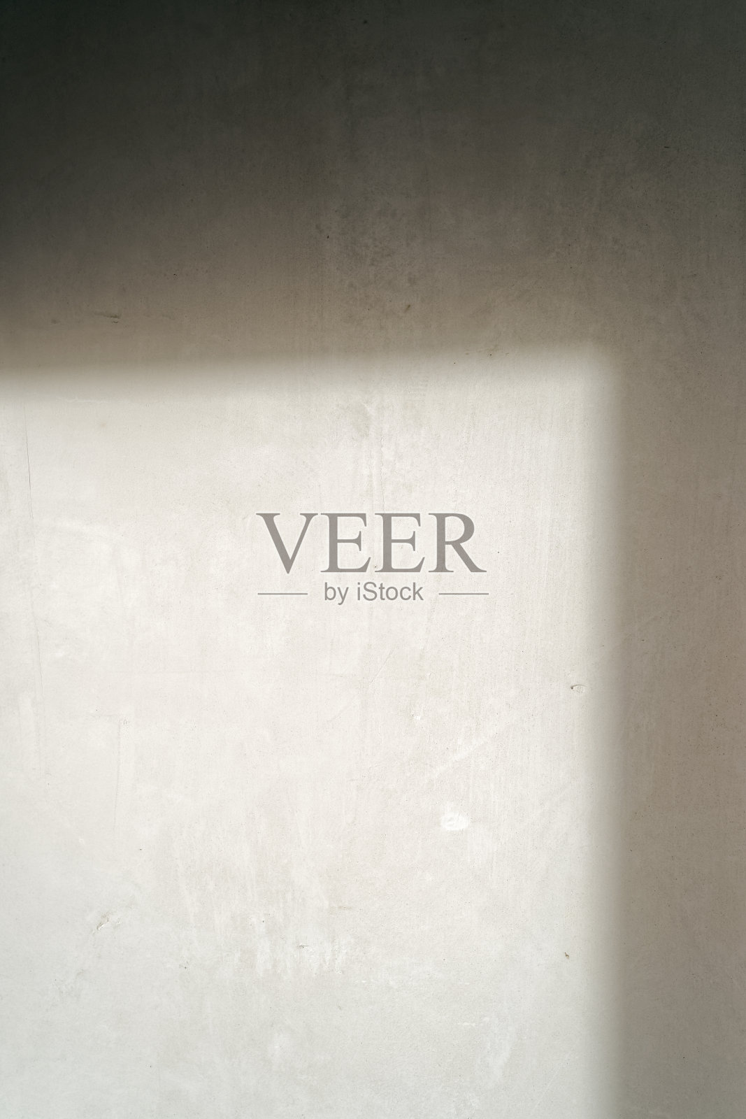 准备翻新的新房间内的墙壁。从窗户斜射进来的光线照在墙上。照片摄影图片