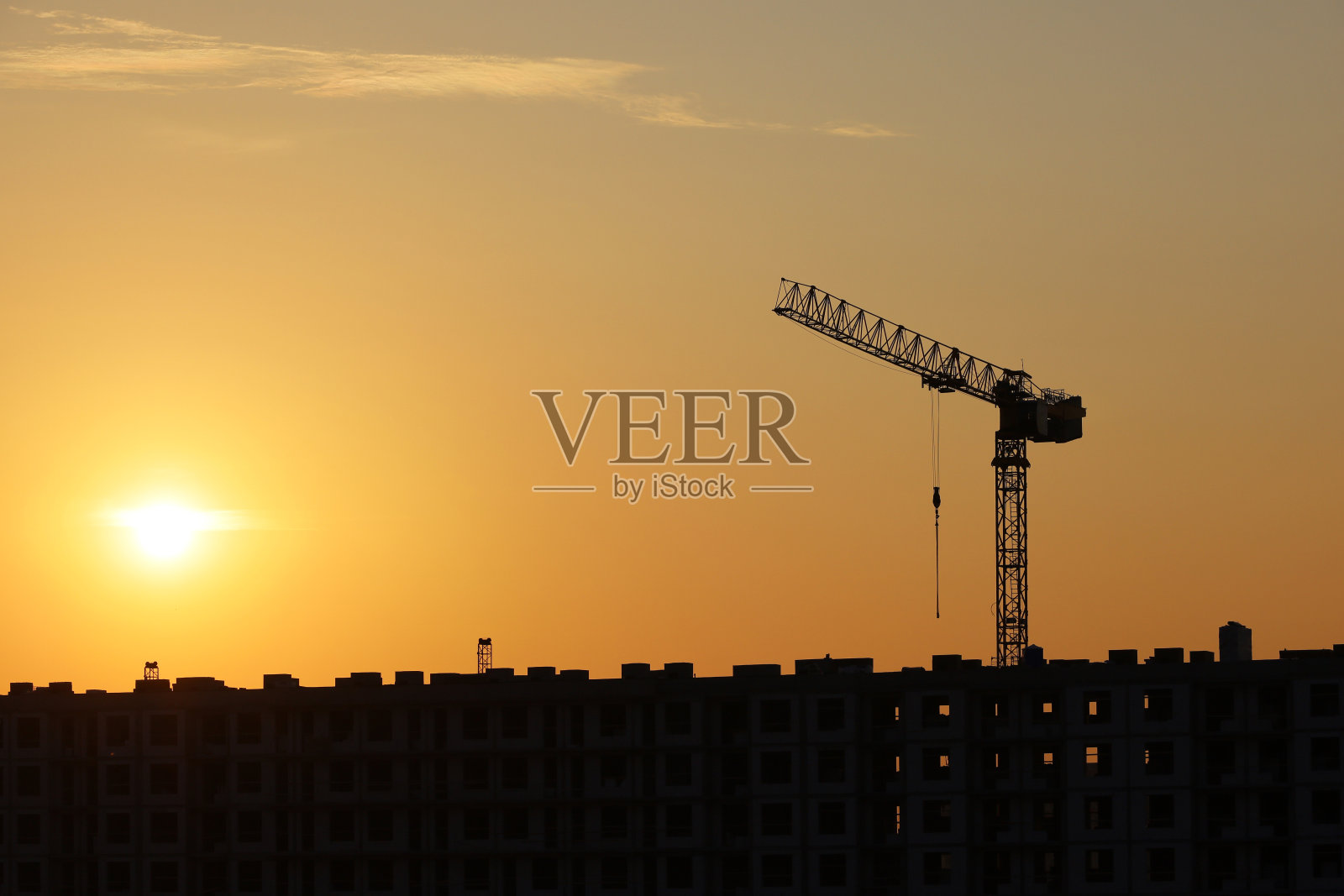 塔吊的剪影和未完工的建筑晨光背景照片摄影图片