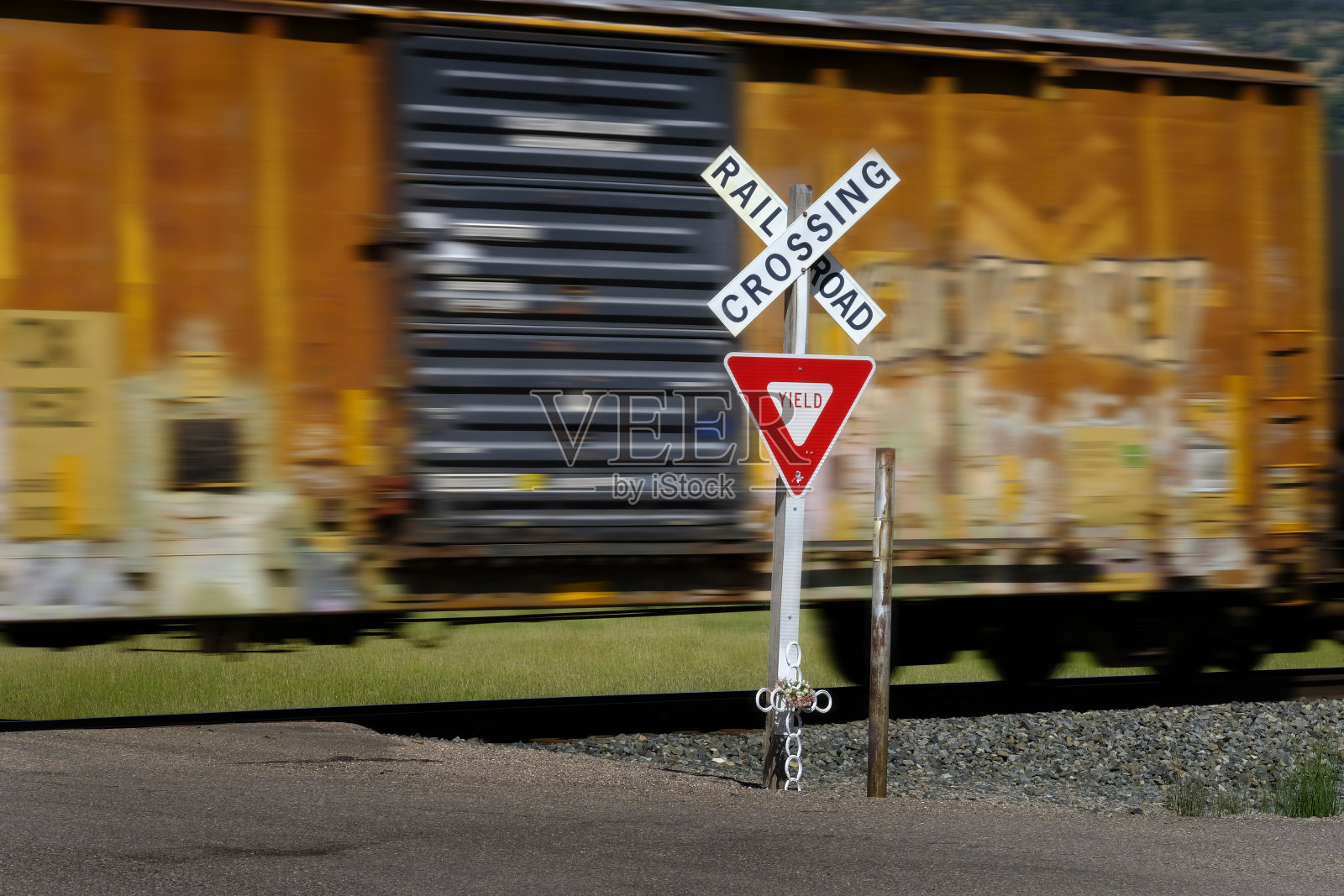 铁路道口标志与铁路车辆和引擎模糊超速照片摄影图片