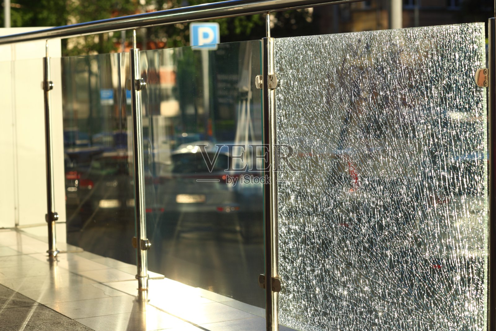 城市中破碎的玻璃栅栏的特写。阳光透过玻璃照射进来。散景。照片摄影图片