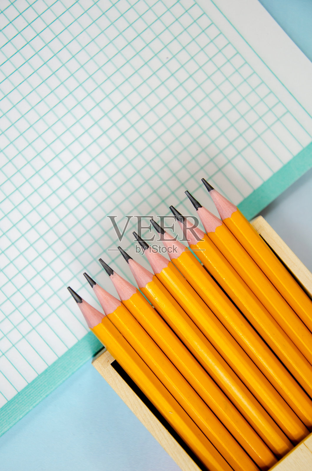 一套装在木箱里的石墨铅笔和一片空白。铅笔在铅笔盒和笔记本纸照片摄影图片