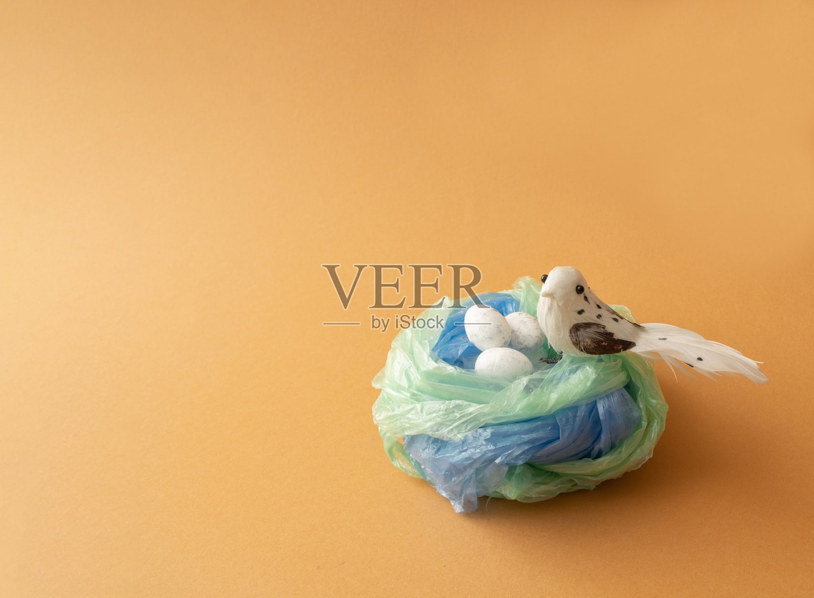 鸟巢是用塑料袋做成的，里面有鸟和蛋。生态与污染问题的概念。照片摄影图片